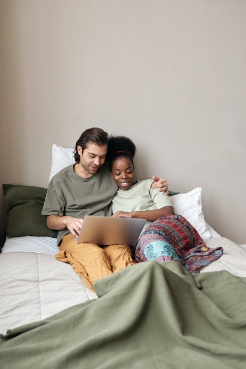 Free Couple With a Laptop in Bed Stock Photo