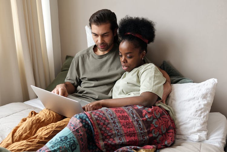 Couple With A Laptop In Bed