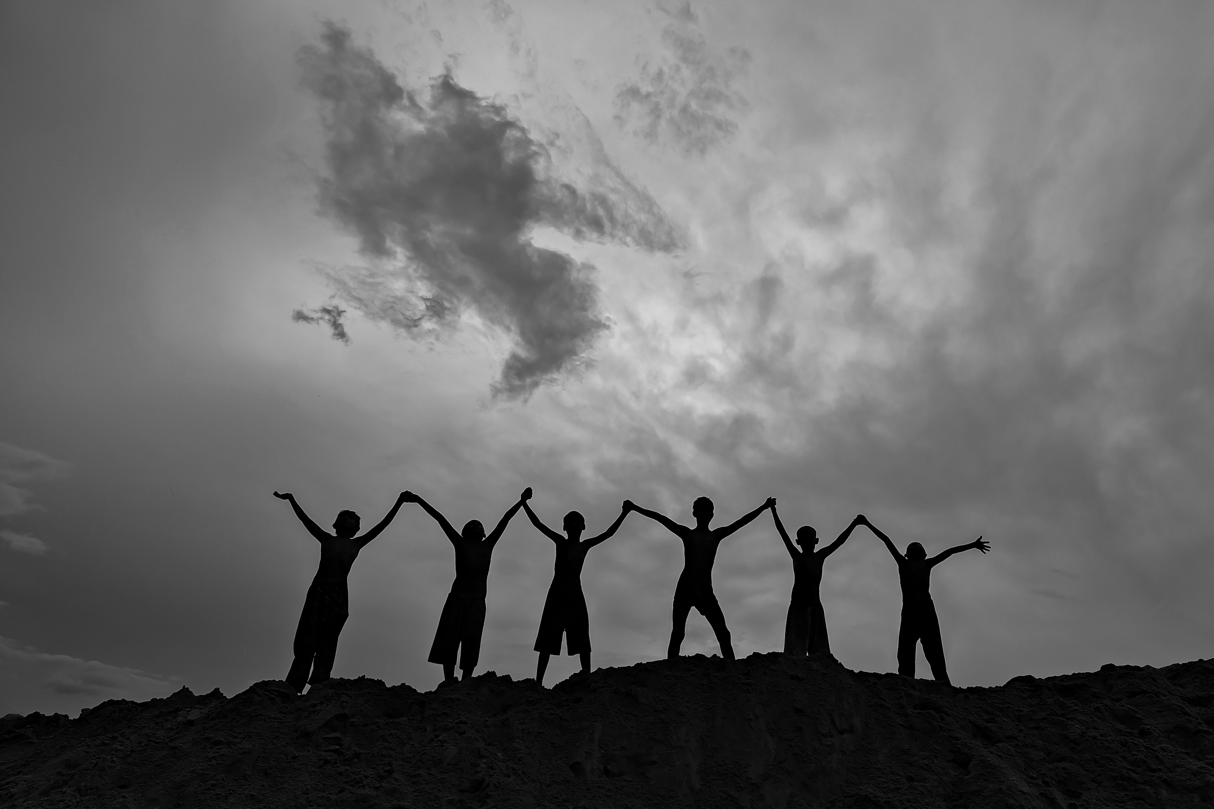 Silhouetted Group Unity Against Dramatic Sky · Free Stock Photo