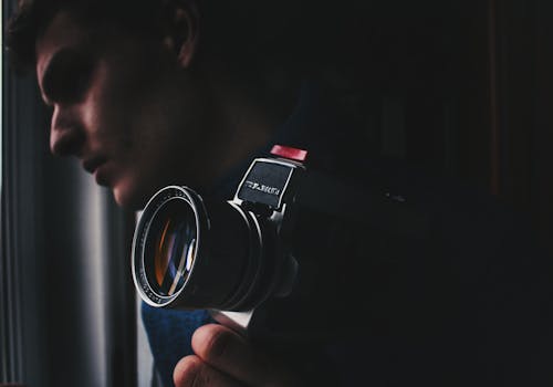 Man Holding Black and Silver Dslr Camera