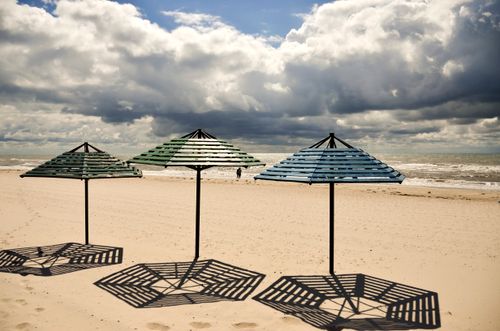 Free A serene beach scene in Лазурне, Ukraine, featuring sunshades and a cloudy sky. Stock Photo