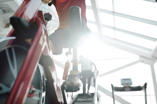 A man with a prosthetic leg works out on a stationary bike in a modern gym setting.