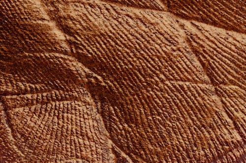 Closeup of abstract rough textured parget surface of brown color with cracks