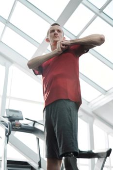 Young man with prosthetic leg exercises indoors, showcasing strength and determination.