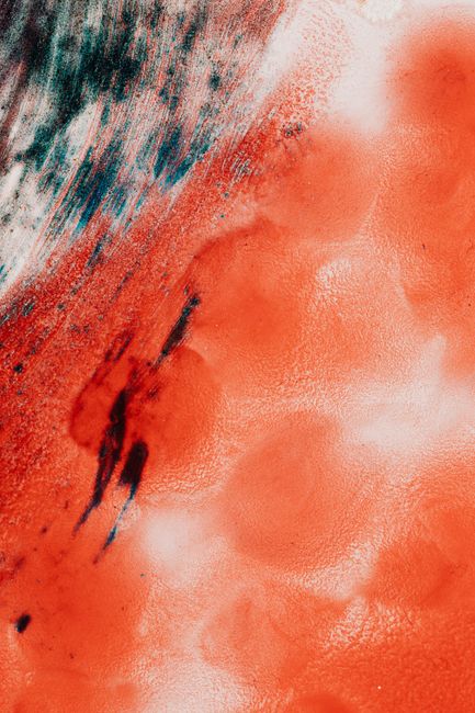 Top view closeup of modern background design with big red blots and ink fluids messed with blue and white colors