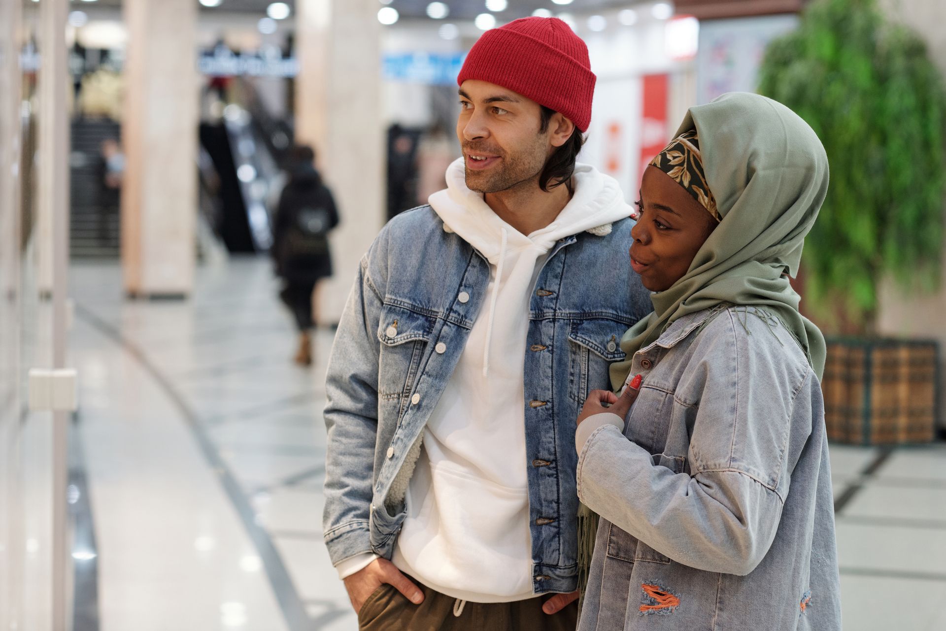 Young multicultural couple enjoying a day shopping at the mall in casual attire.