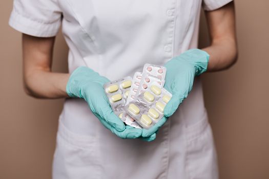 一位身穿制服、手戴手套的医疗保健专业人士，手持泡罩包装的药丸，展示医疗保健服务