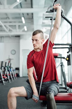 Man with prosthetic leg stretches using resistance band in modern gym.