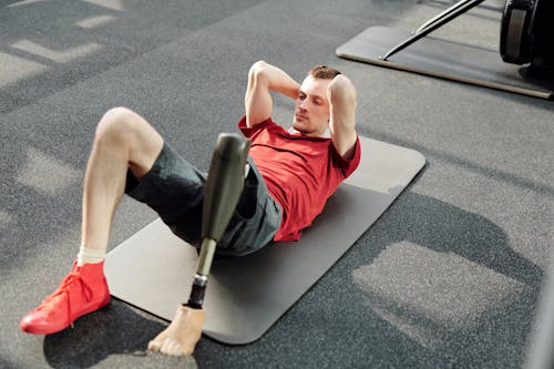 Man in Red Tank Top Lying on Gray Yoga Mat