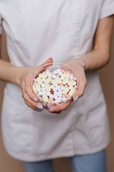 特写镜头中，医护人员在培养皿里拿着各种药丸