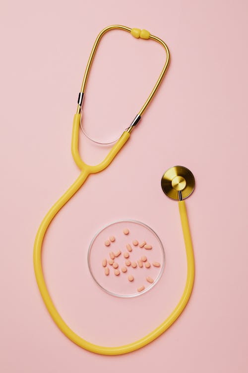 Free Yellow Stethoscope And Pills On Pink Background Stock Photo