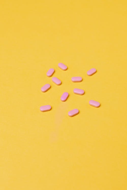 Free Pink Medicines On Yellow Background Stock Photo