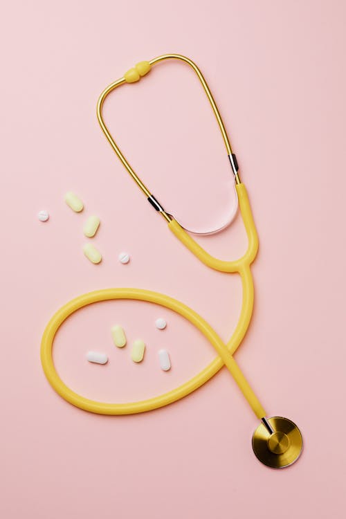 Yellow Stethoscope And Medicines On Pink Background