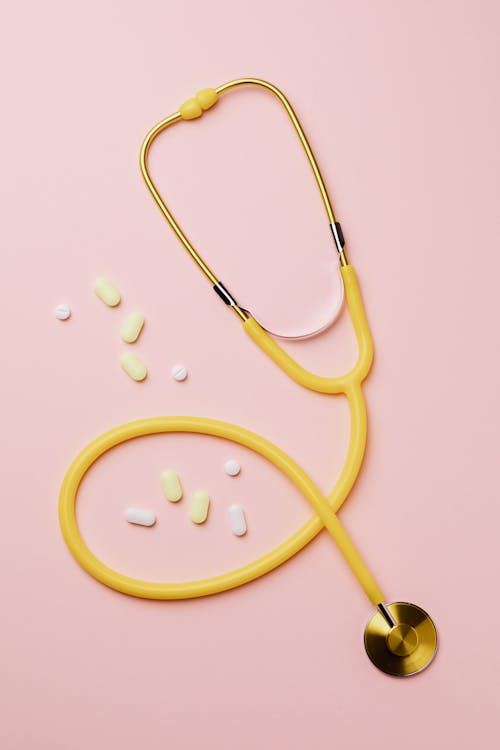 Free Yellow Stethoscope And Medicines On Pink Background Stock Photo
