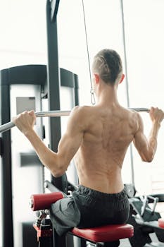 Muscular man with prosthetic leg lifting weights in a gym setting.
