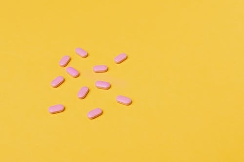 Pink Tablets on Yellow Surface