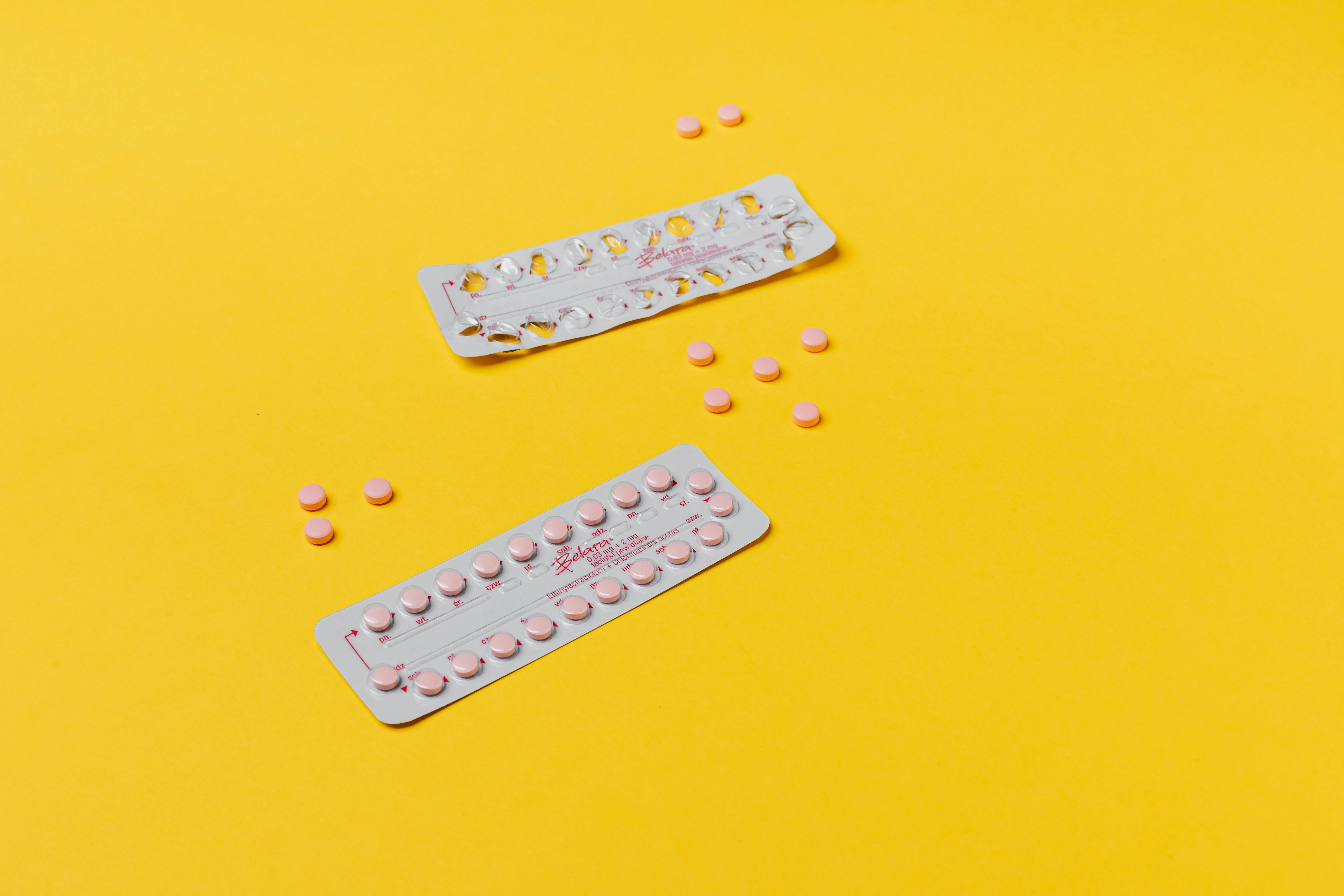 pink pills on yellow surface