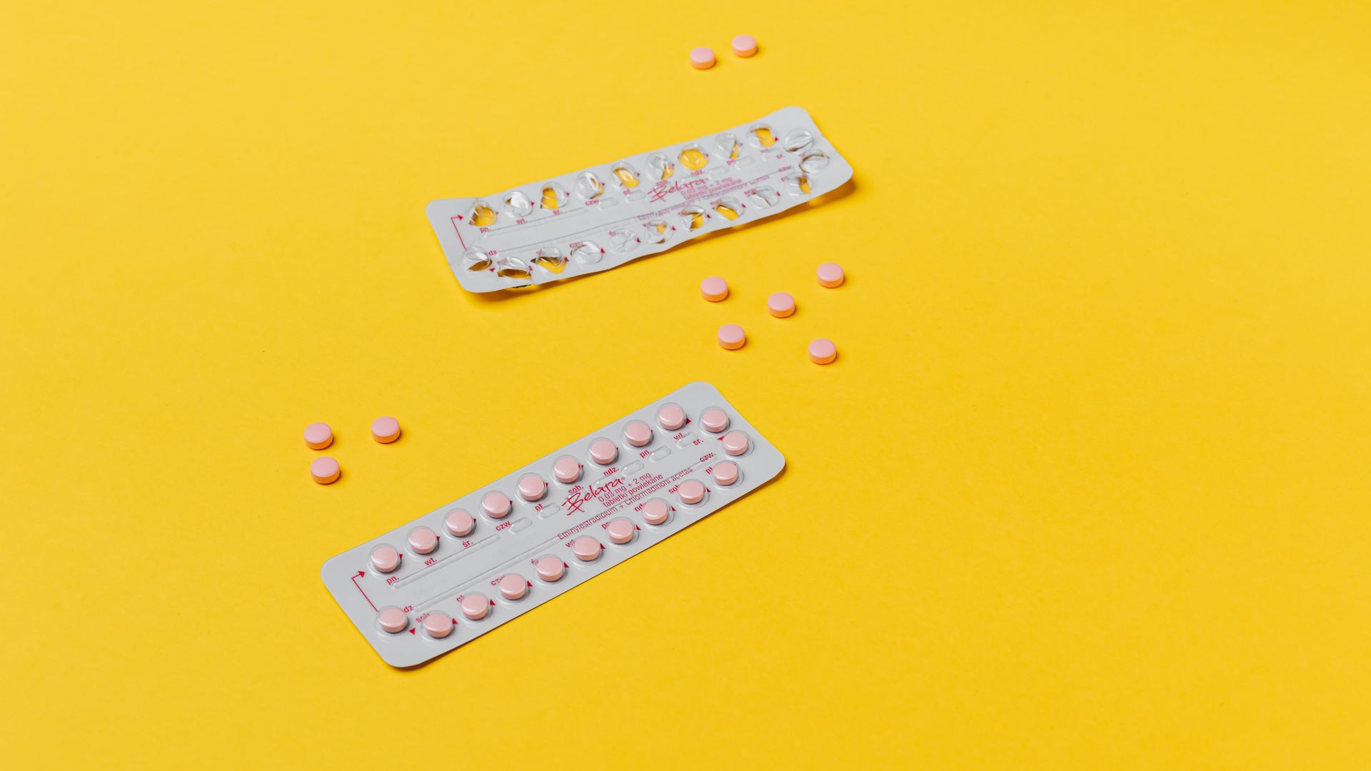 Modafinil and Birth Control Interaction: What You Need to Know Pink pills and blister packs on a vibrant yellow background, symbolizing healthcare — modafinil and birth control interaction