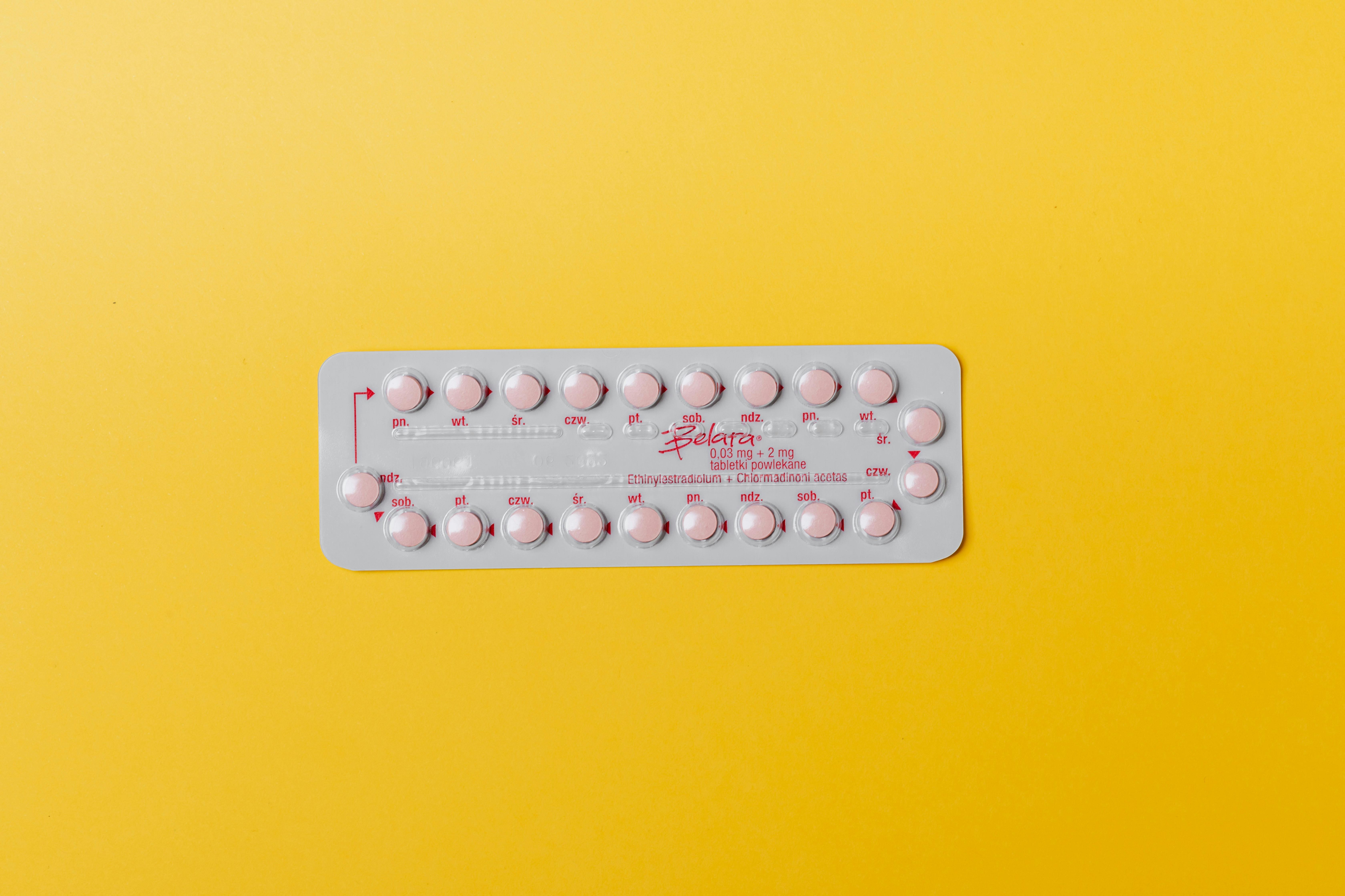 pink pills on yellow surface