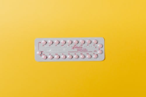 Pink Pills on Yellow Surface