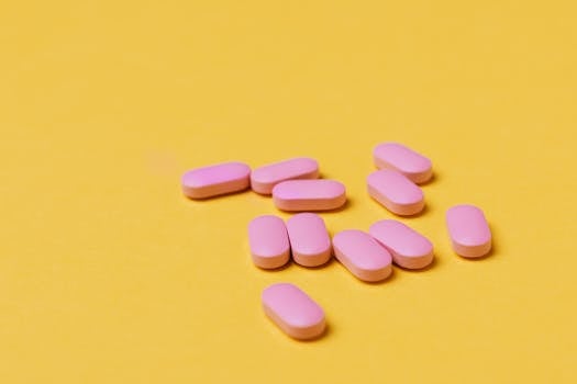 Close-up of pink tablets on a vivid yellow background, perfect for medical themes.