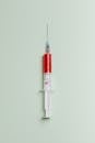 浅色背景上，一支充满红色液体的注射器的高质量特写