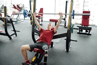 一名戴着假腿的年轻人在现代健身房举重，展现了决心与力量