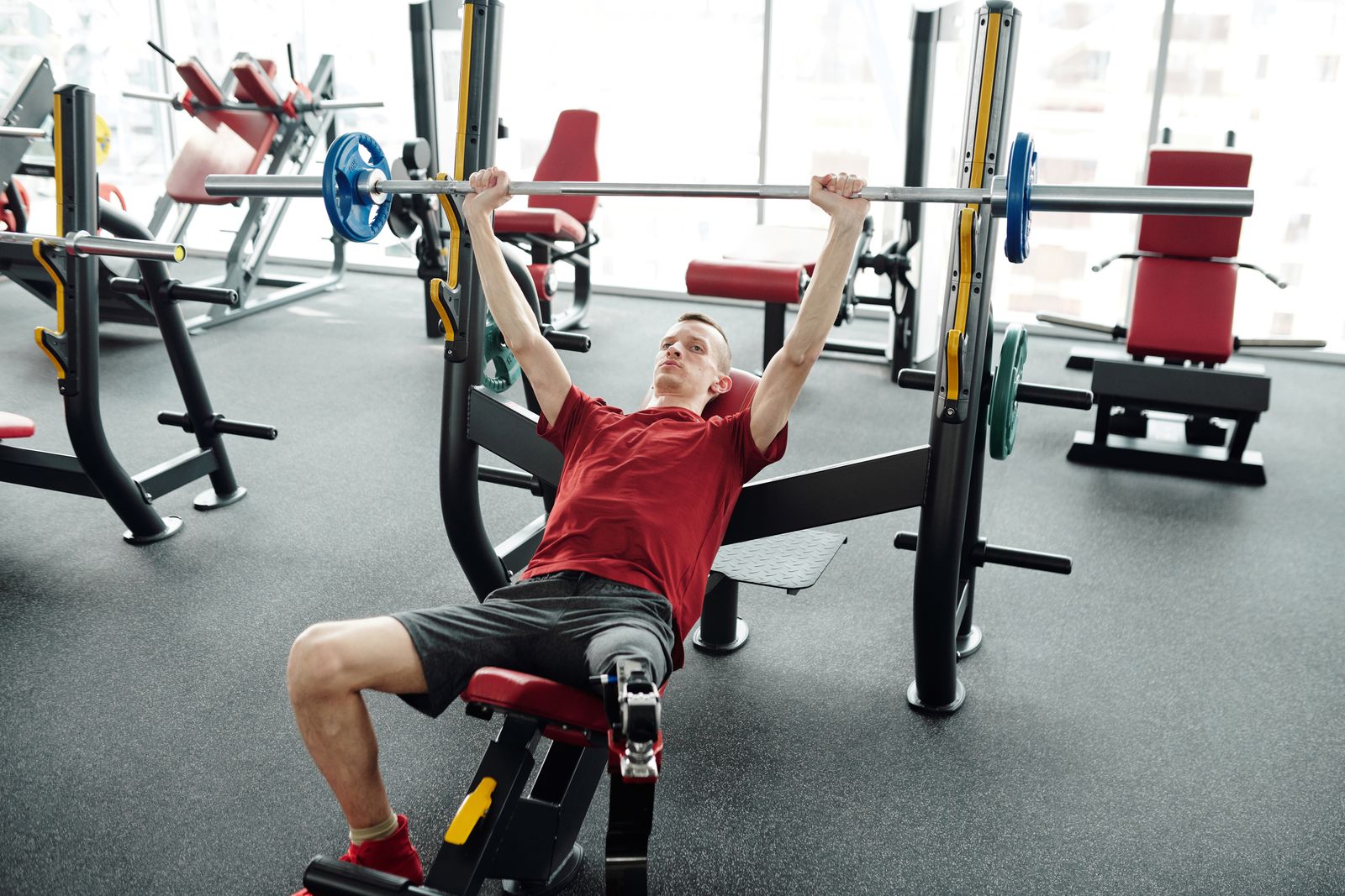 Person gently stretching a shoulder in a bright exercise space