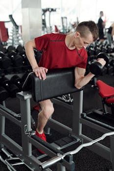 Determined man with prosthetic leg doing bicep curls in a gym setting.