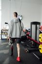 Man in Gray Sweater and Black Shorts Holding Water Bottle ang Gym Bag