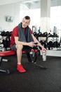 Man in Red Shirt and Black Shorts Sitting on Red and Black Chair