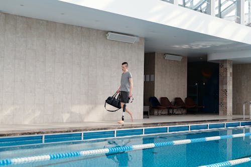 Man with Prosthetic Leg Walking by Swimming Pool