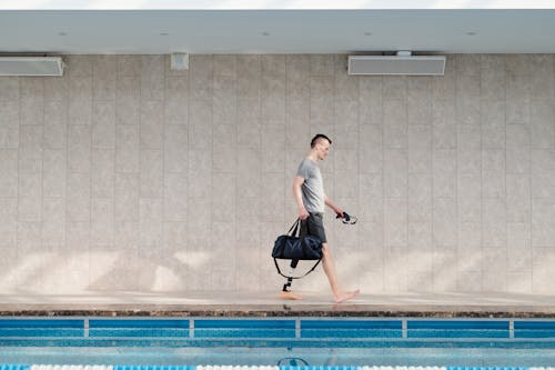 Man with Prosthetic Leg Walking by Swimming Pool