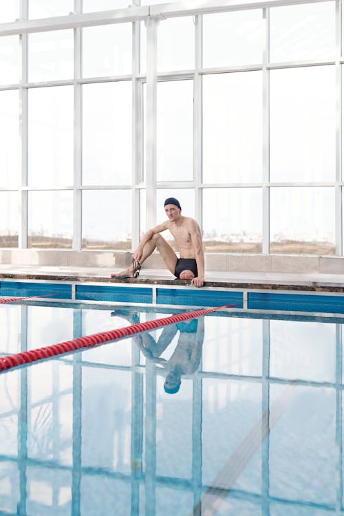 Man in Black Shorts Sitting in Swimming Pool