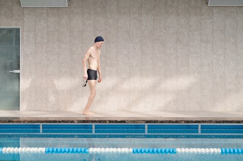 Man in Black Shorts Standing on Swimming Pool