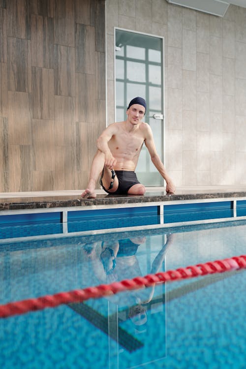 Man in Black Shorts Sitting on Pool