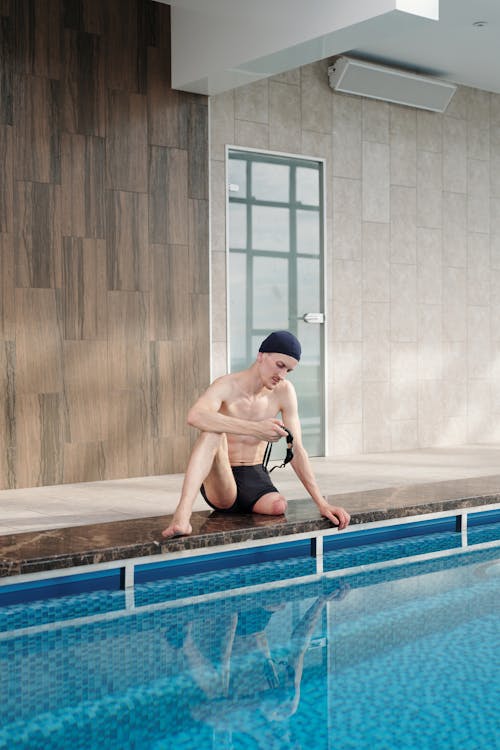 Man in Black Shorts Sitting on Pool