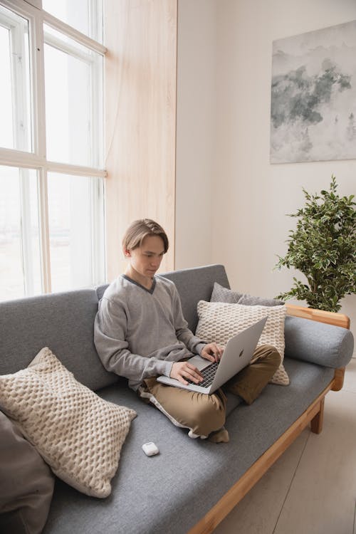 Free Man Sitting on the Couch with His Laptop Stock Photo
