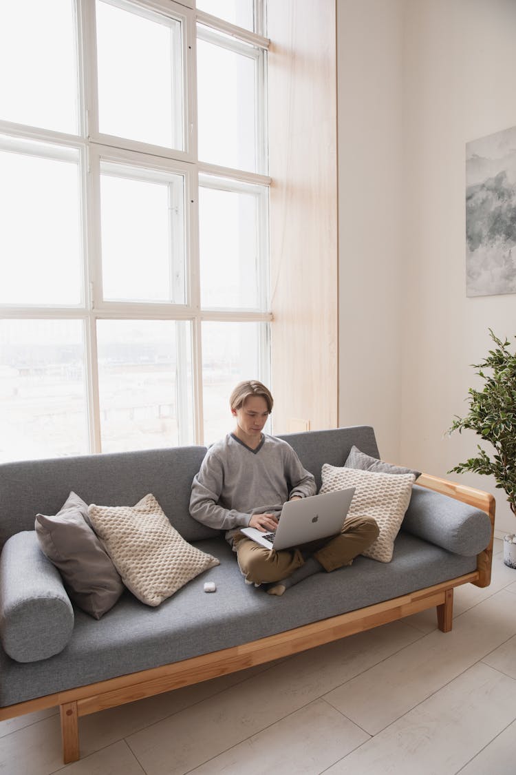 Man Sitting On The Couch With His Laptop