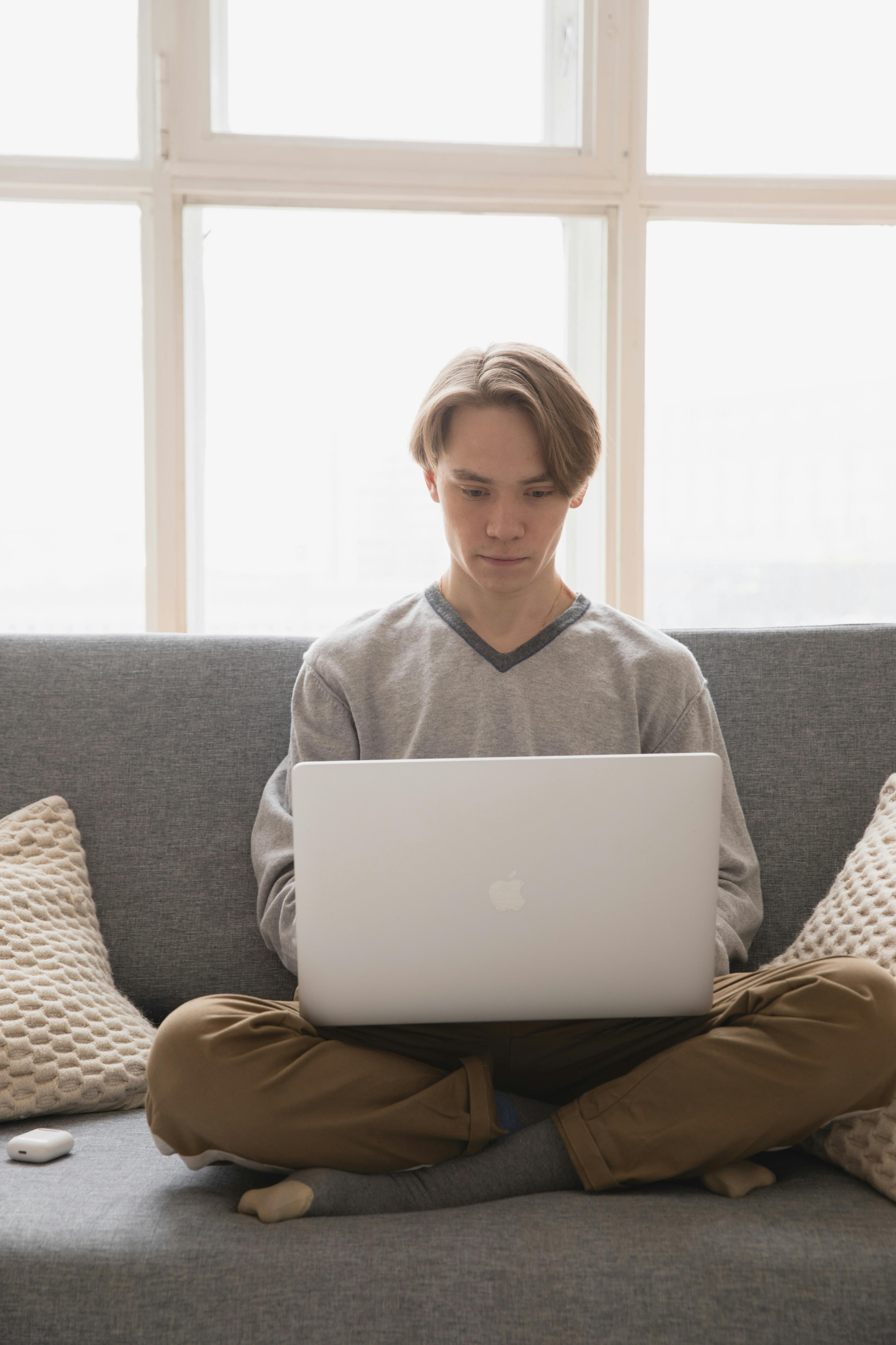 male freelancer surfing internet on laptop at home