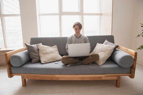 Free Man Sitting on the Couch with His Laptop Stock Photo