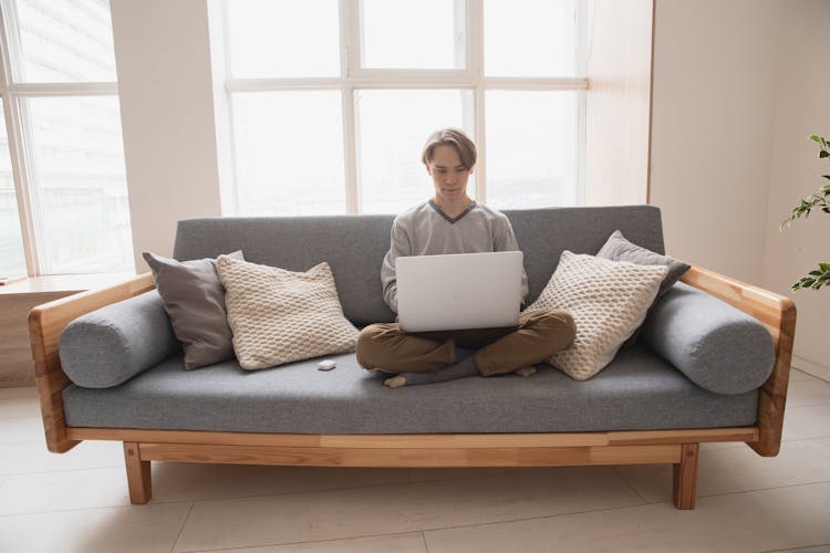 Man Sitting On The Couch With His Laptop