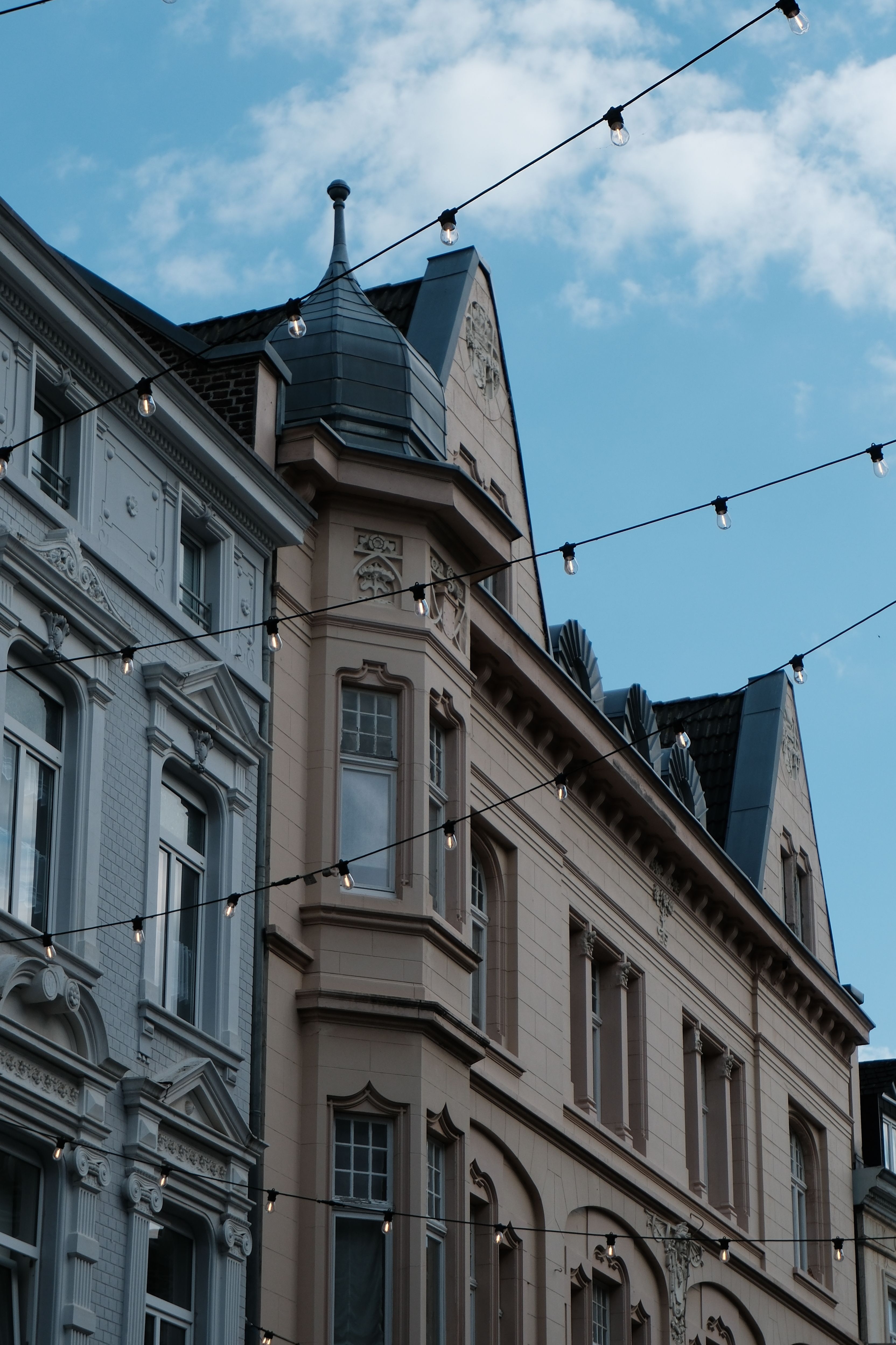 Beautiful vintage buildings adorned with string lights under a clear sky.