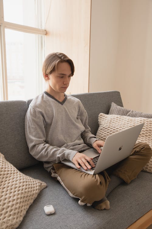 Thoughtful male freelancer working on laptop at home in daylight