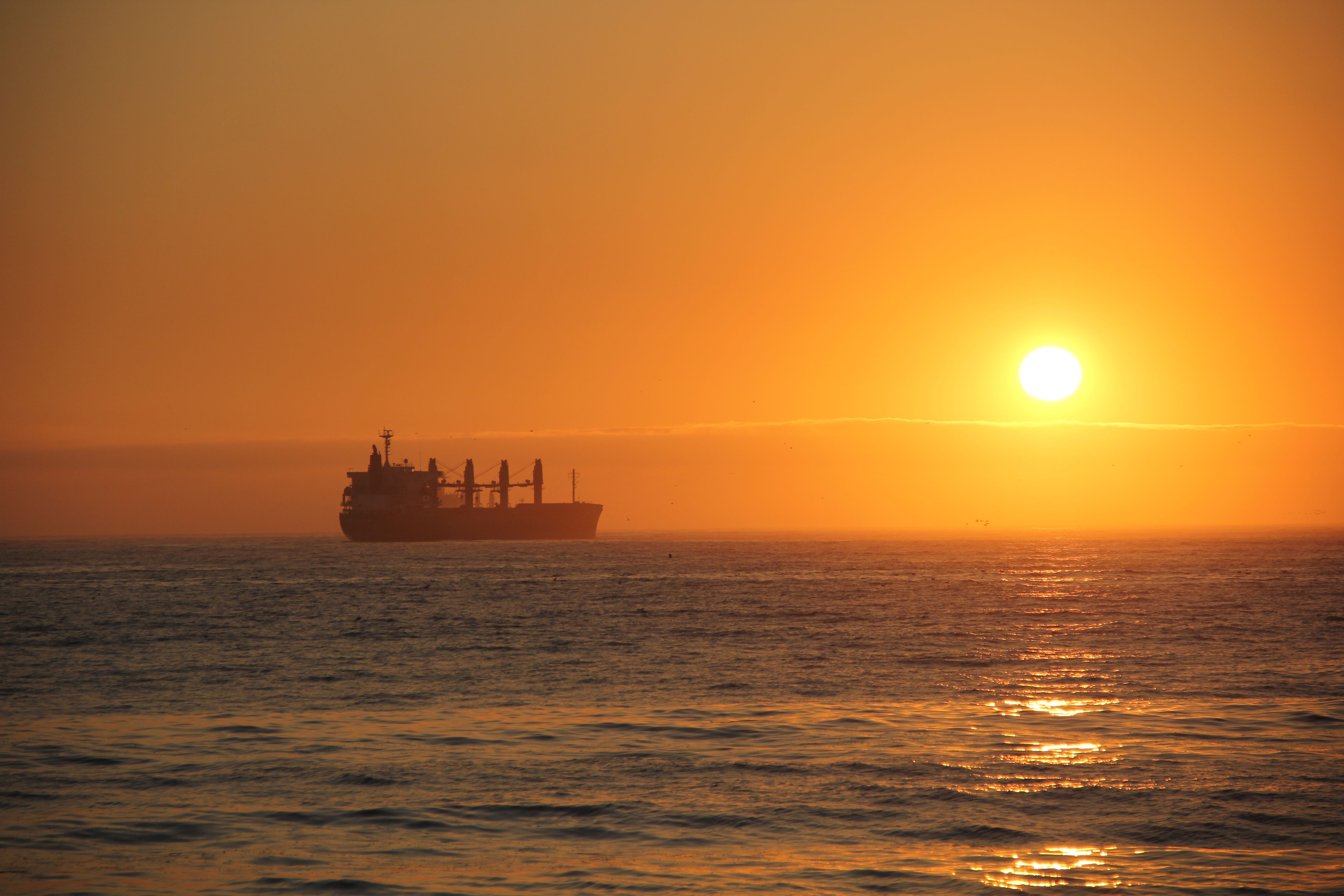 Sunset over Pacific Ocean with Cargo Ship · Free Stock Photo