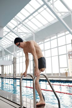 Amputee swimmer on pool ladder showcasing strength and determination.