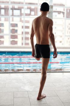 一名截肢的男性运动员准备游泳，展现了决心和力量