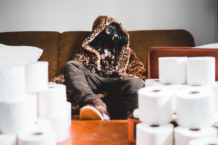 Unrecognizable Trendy Man In Respirator Near Pile Of Toilet Paper