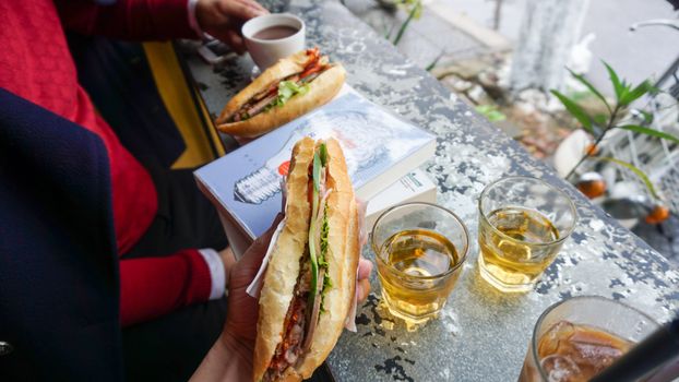 Delicious banh mi sandwiches with drinks at an outdoor cafe in Da Nang, Vietnam.
