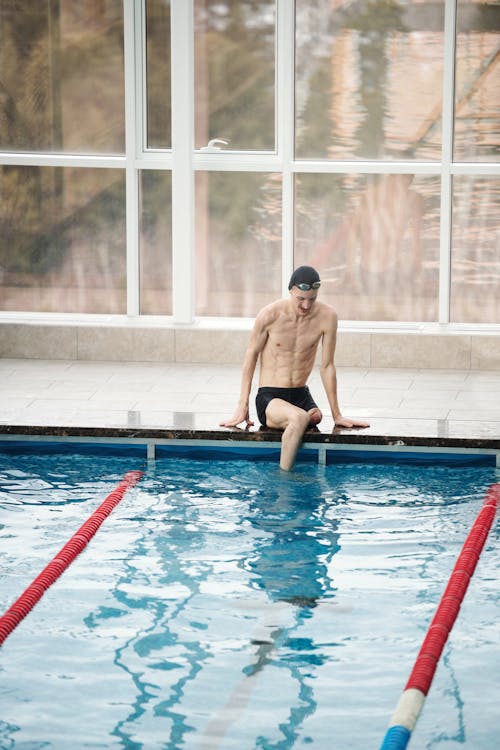 Photo Of Man Sitting Beside Pool 